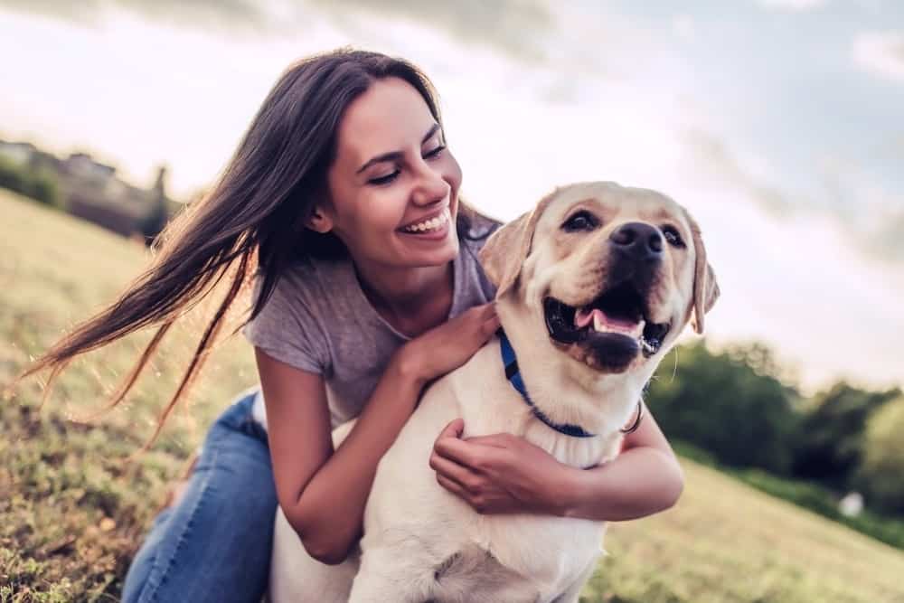 Happy girl playing with her dog